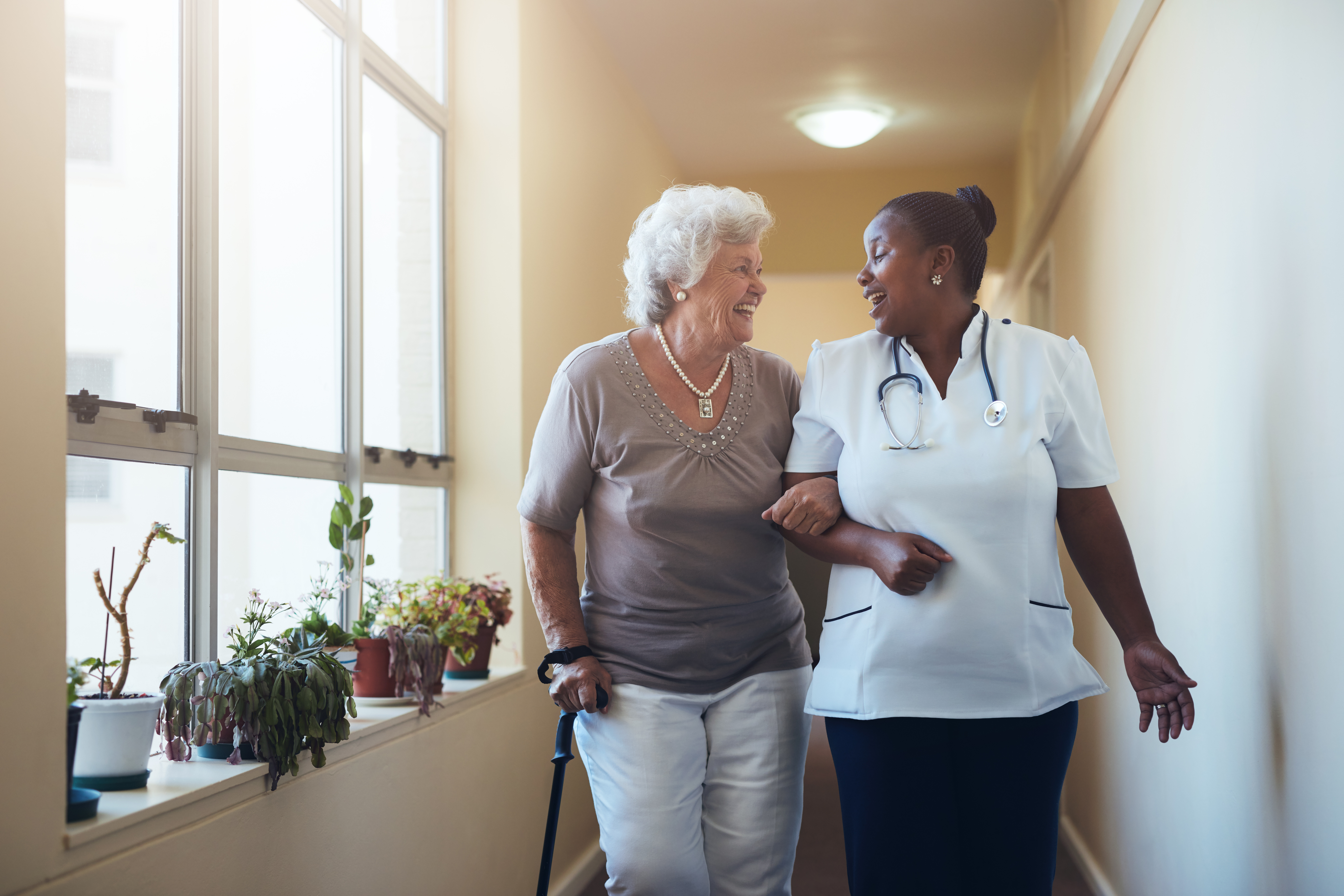 a nurse walking with an elderly woman
