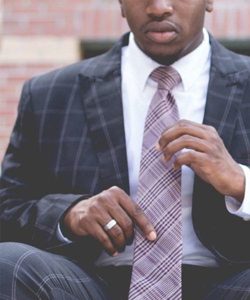 a suited person holding his tie