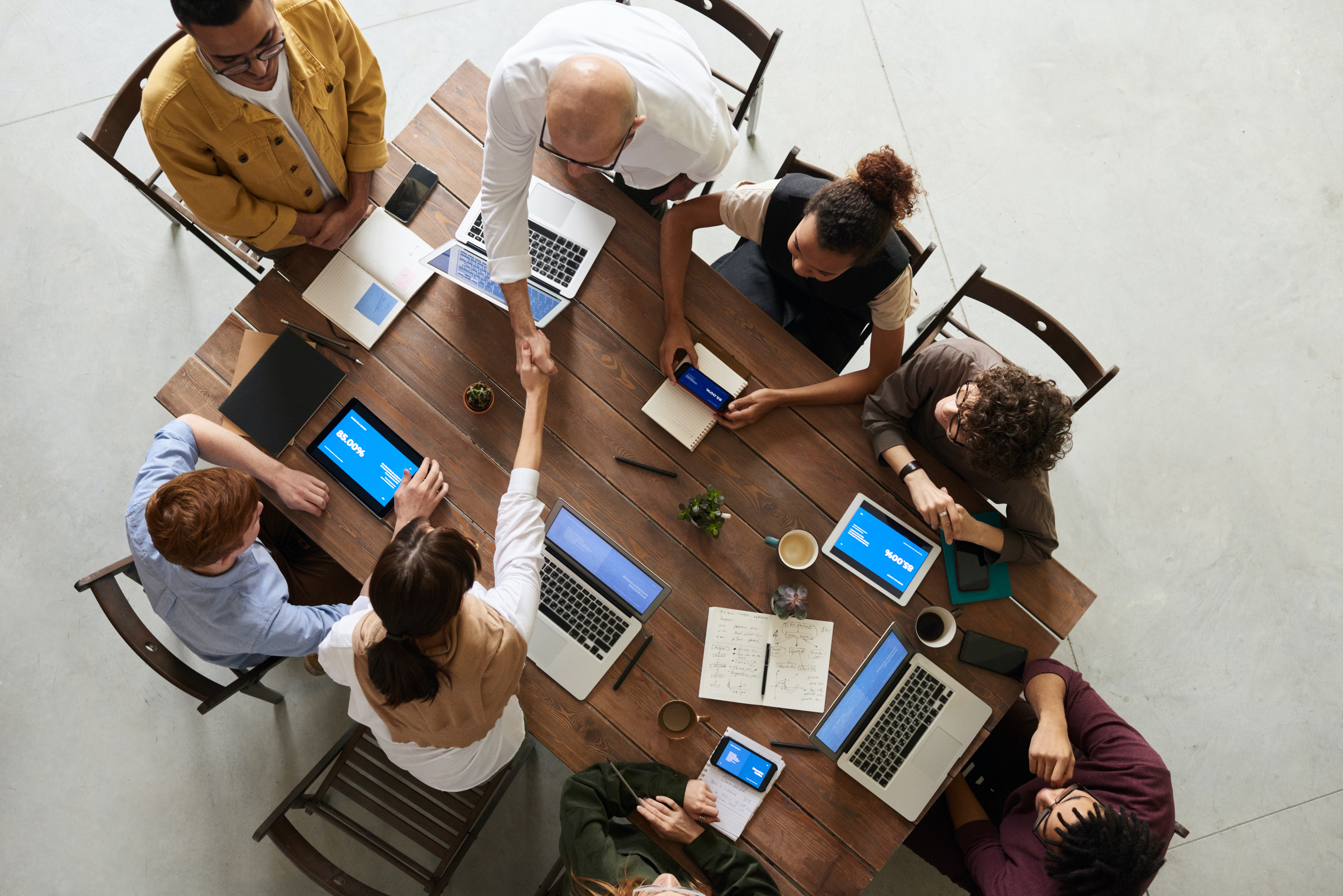 a group of people sitting around a table and working