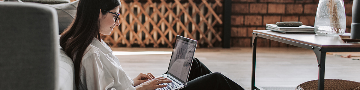 a girl studying on her laptop remotely at the comfort of her home.