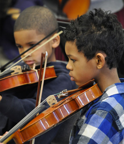 two young boys playing violins